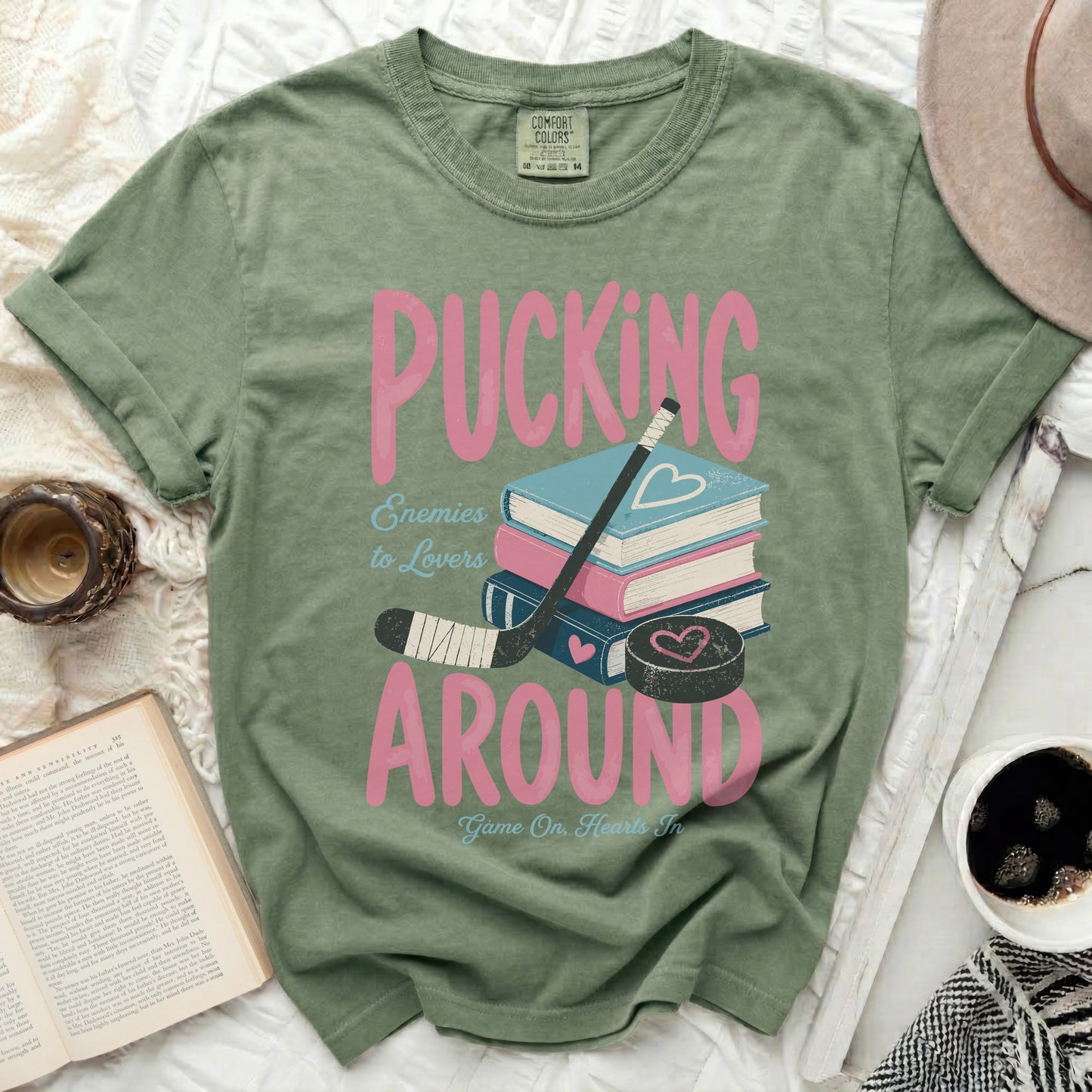 Green t-shirt with "Pucking Around" and hockey puck graphic.