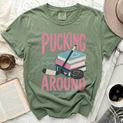 Green t-shirt with "Pucking Around" and hockey puck graphic.