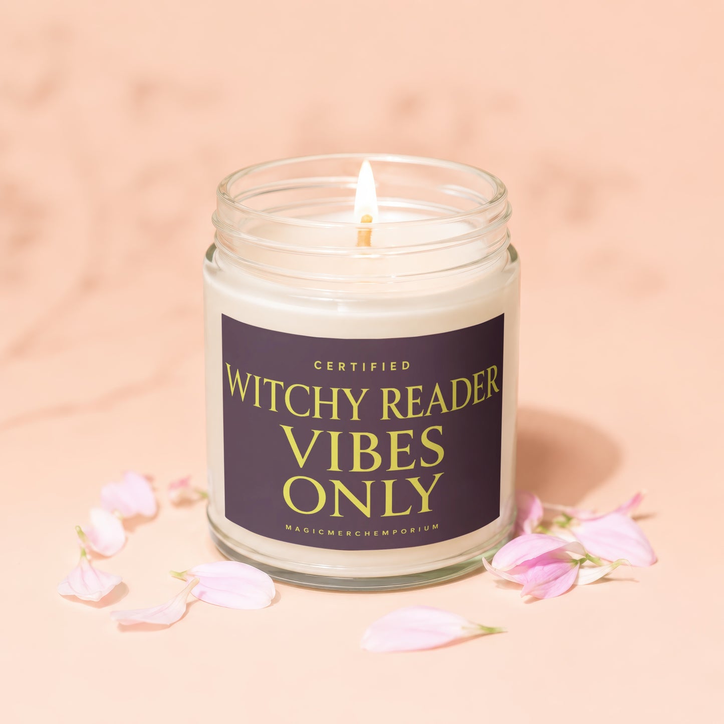 Candle with label "Certified Witchy Reader Vibes Only" surrounded by pink petals.