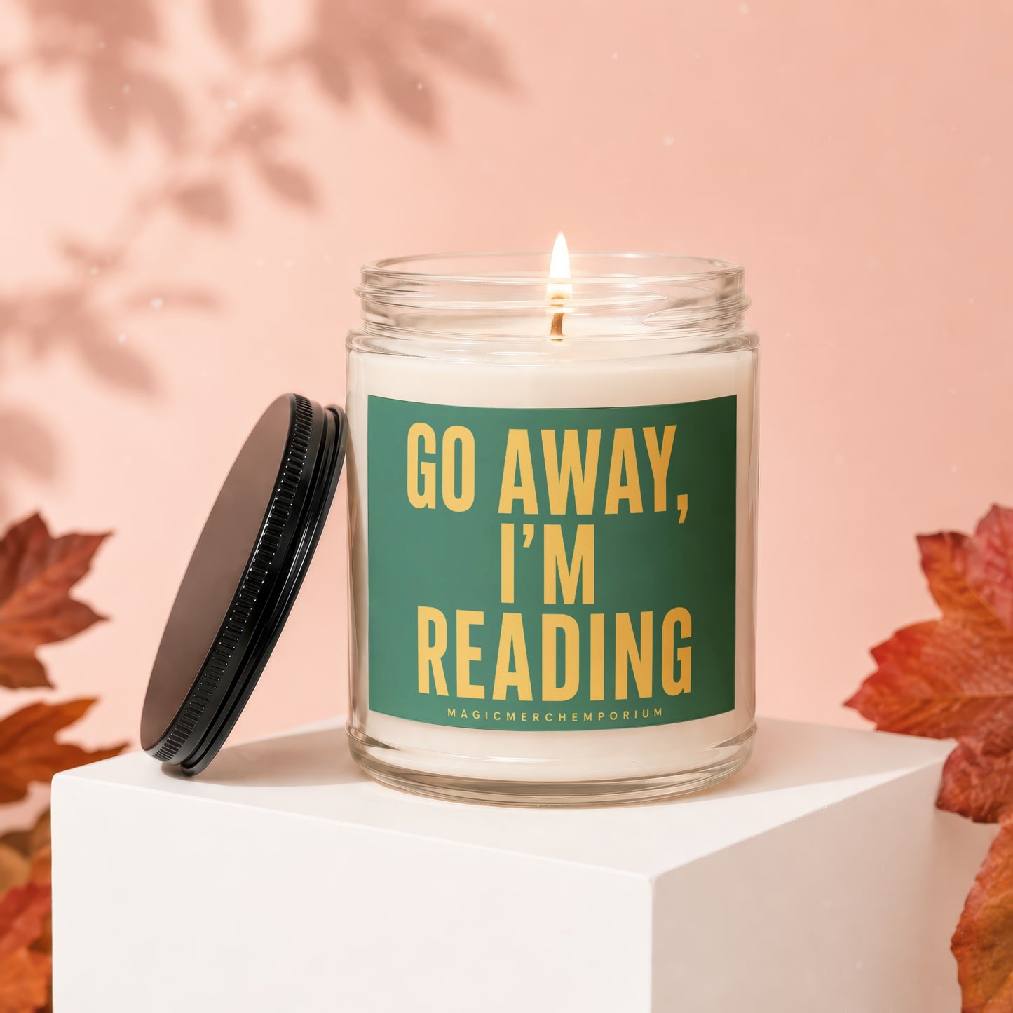 Glass candle with green label reads "Go Away, I'm Reading."