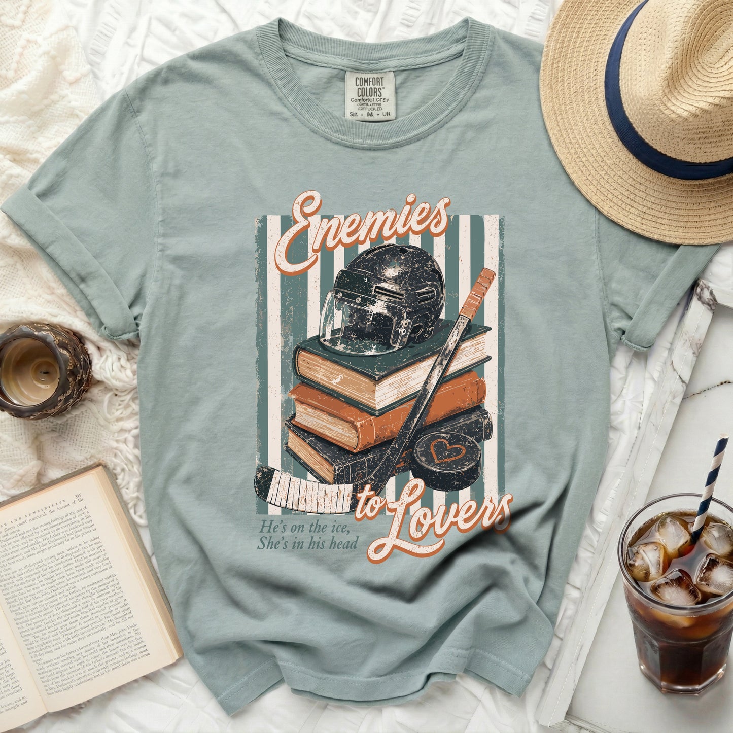 T-shirt with hockey helmet, books, and text "Enemies to Lovers."