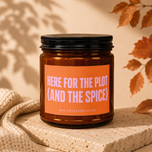 Amber candle in jar with orange label reading "HERE FOR THE PLOT (AND THE SPICE)".
