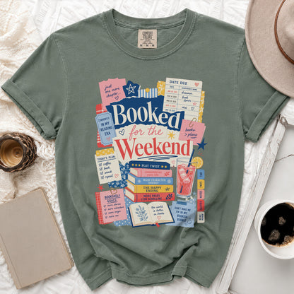 Green t-shirt graphic with text "Booked for the Weekend" and book-themed illustrations.