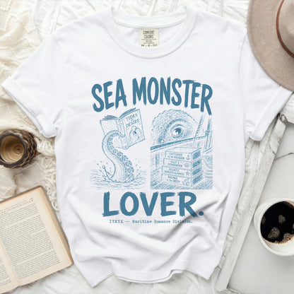White t-shirt with "SEA MONSTER LOVER" in blue text and nautical illustrations.