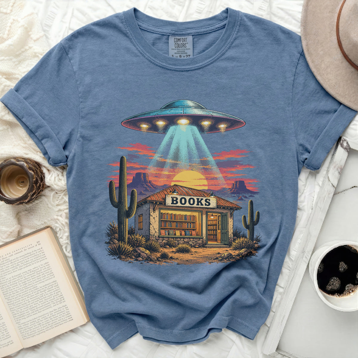 UFO beaming light onto a desert bookstore with "BOOKS" sign.