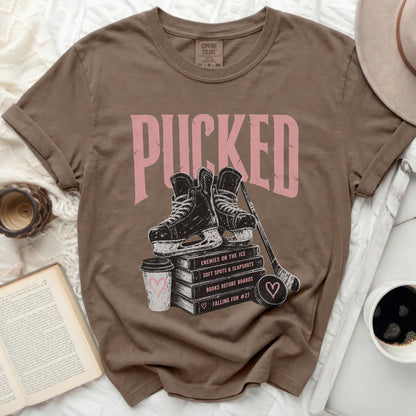 Brown t-shirt with "PUCKED" and hockey imagery.