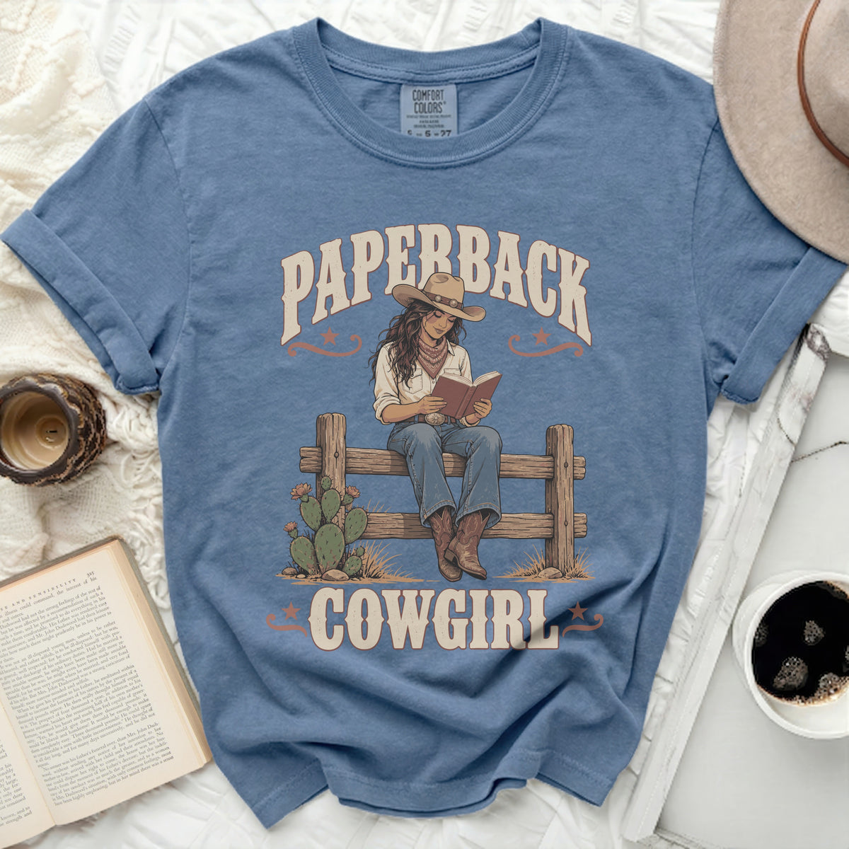Graphic tee with "Paperback Cowgirl" text and illustration of a cowgirl reading.