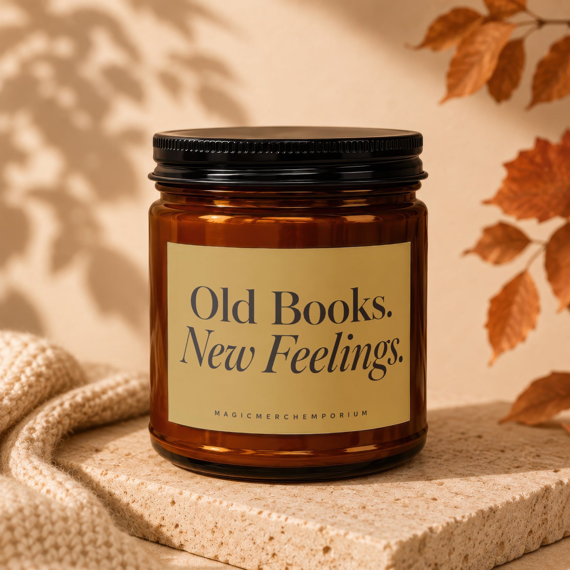 Amber glass candle with black lid, featuring a cream label with text "Old Books. New Feelings."