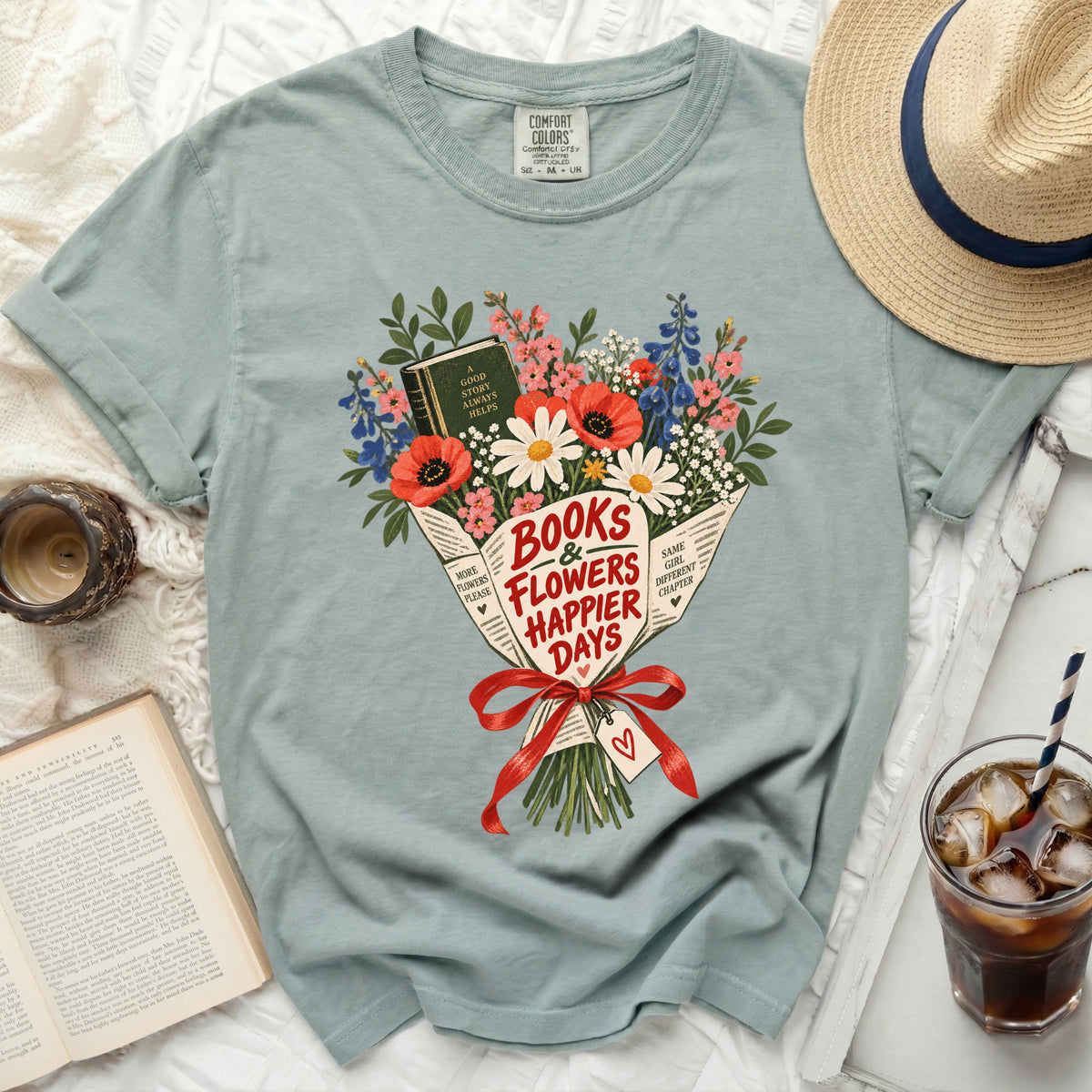 Light blue t-shirt with a bouquet graphic featuring a book and the text "Books & Flowers Happier Days".