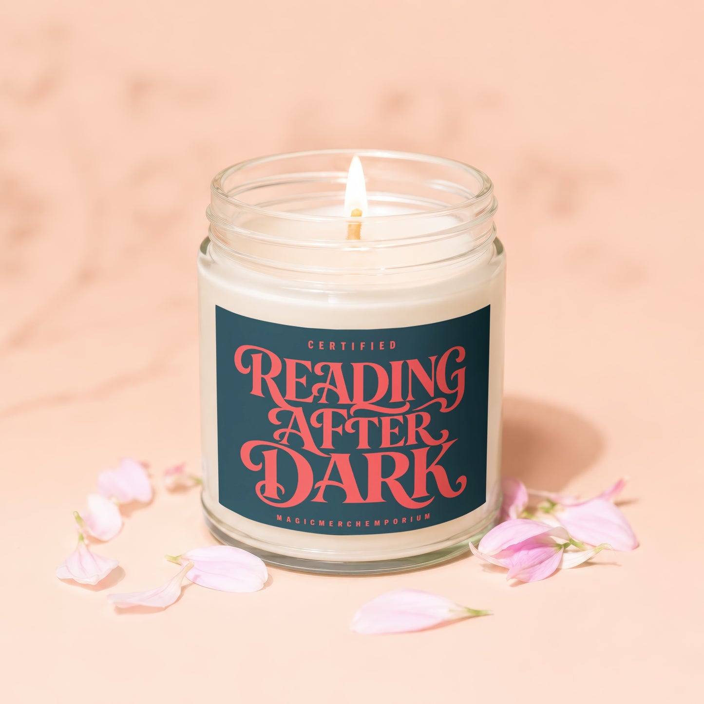 Candle with "Reading After Dark" label and pink flower petals.