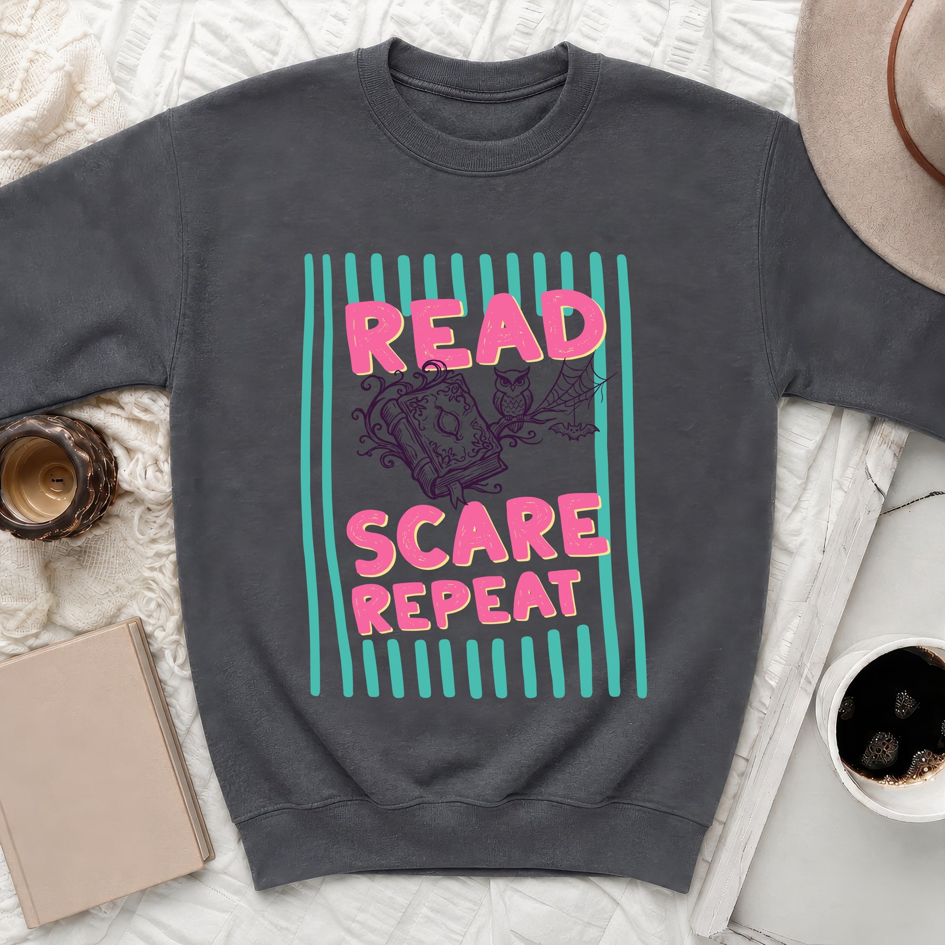 Dark grey sweatshirt graphic with "Read Scare Repeat" text and Halloween imagery.