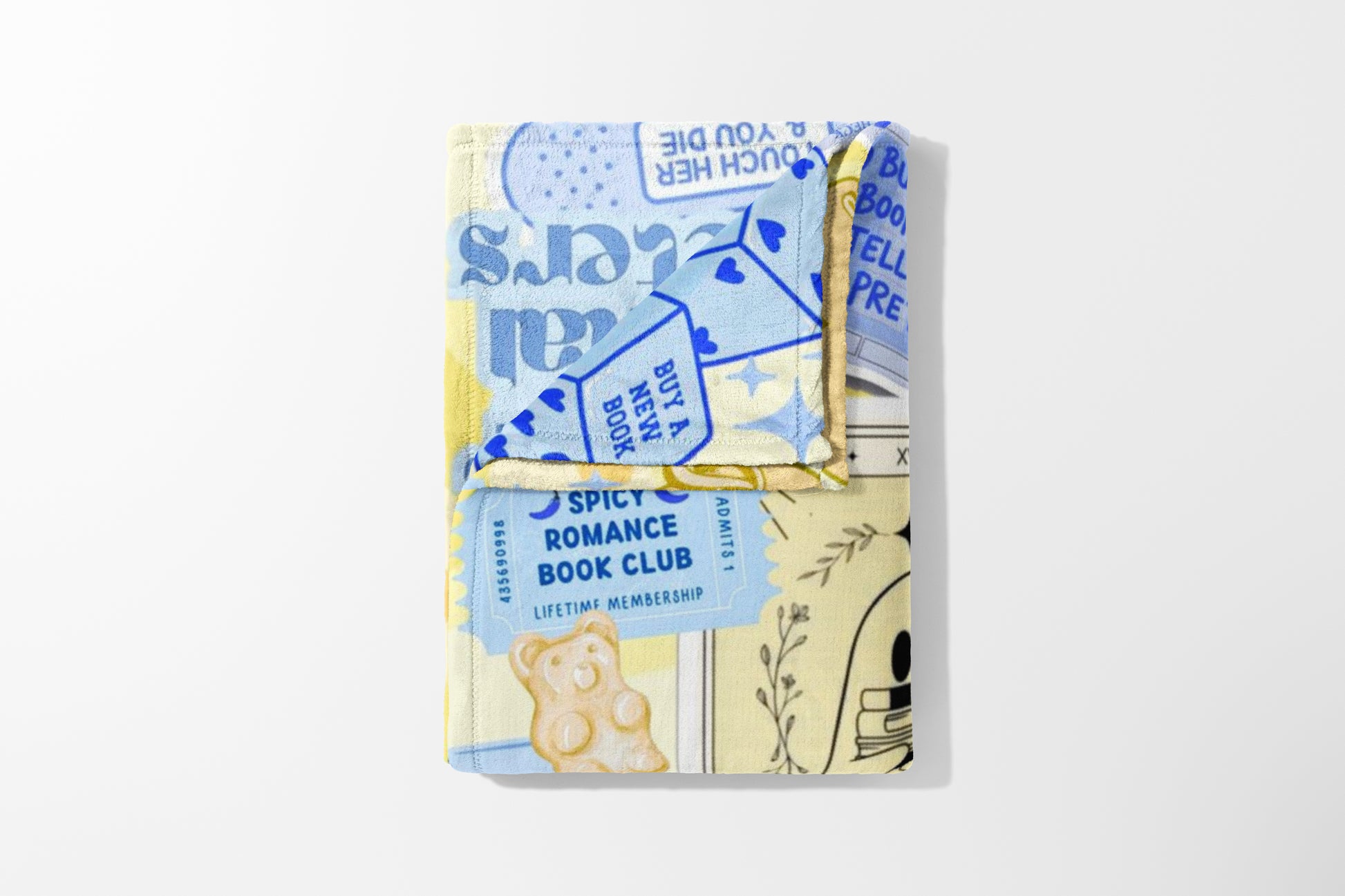 Blanket with yellow and blue pattern, featuring "Spicy Romance Book Club" text and gummy bear.