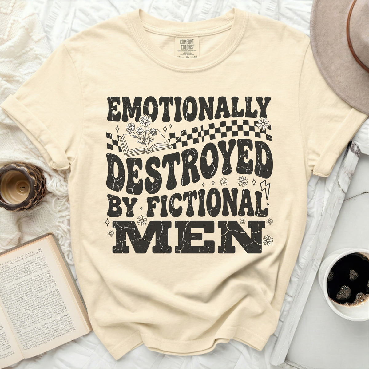 Cream t-shirt with black graphic text "EMOTIONALLY DESTROYED BY FICTIONAL MEN."