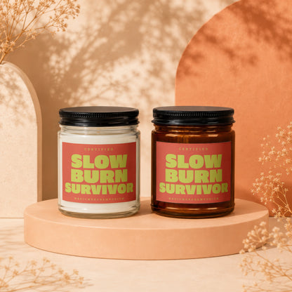 Two candles with red labels reading "CERTIFIED SLOW BURN SURVIVOR".