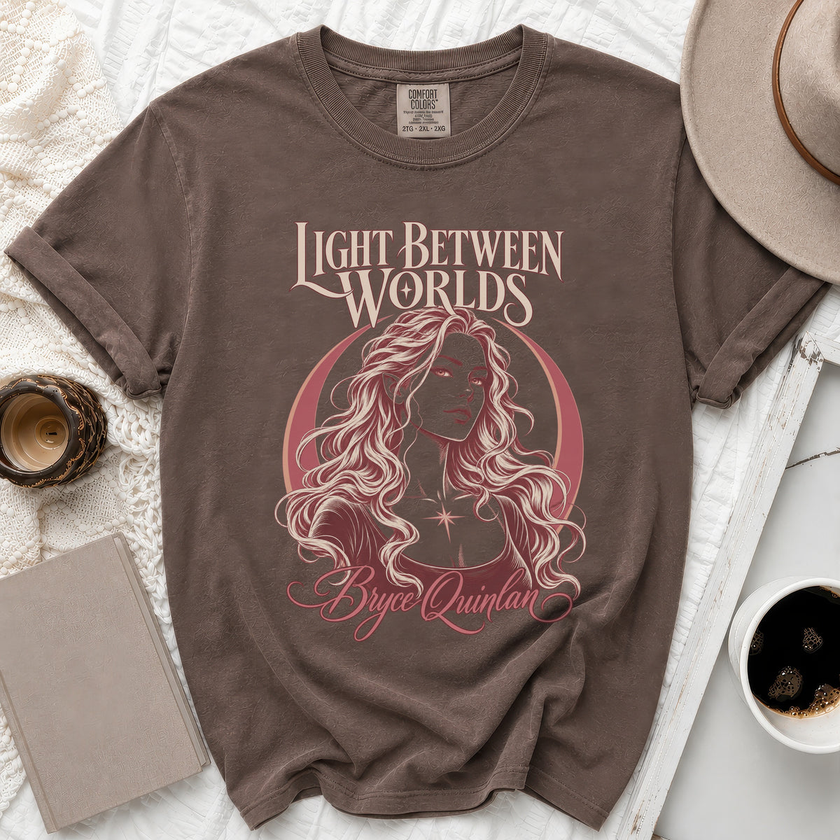 Brown t-shirt with "Light Between Worlds" and "Bryce Quinlan" text and illustration.