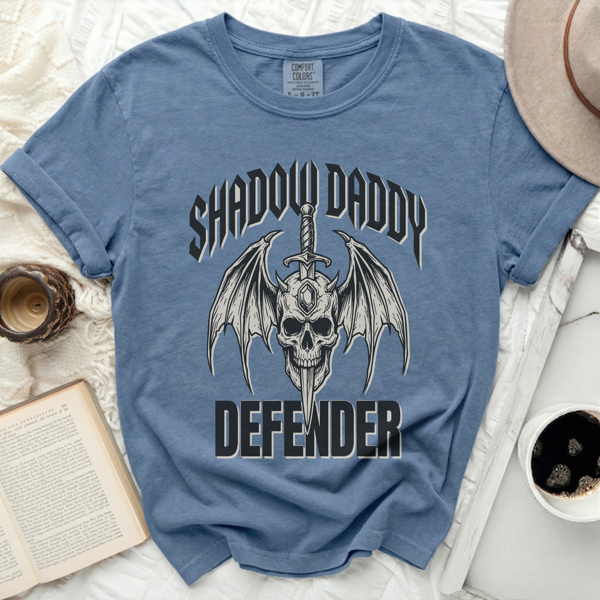 Blue t-shirt with skull, wings, sword, and text "Shadow Daddy Defender".