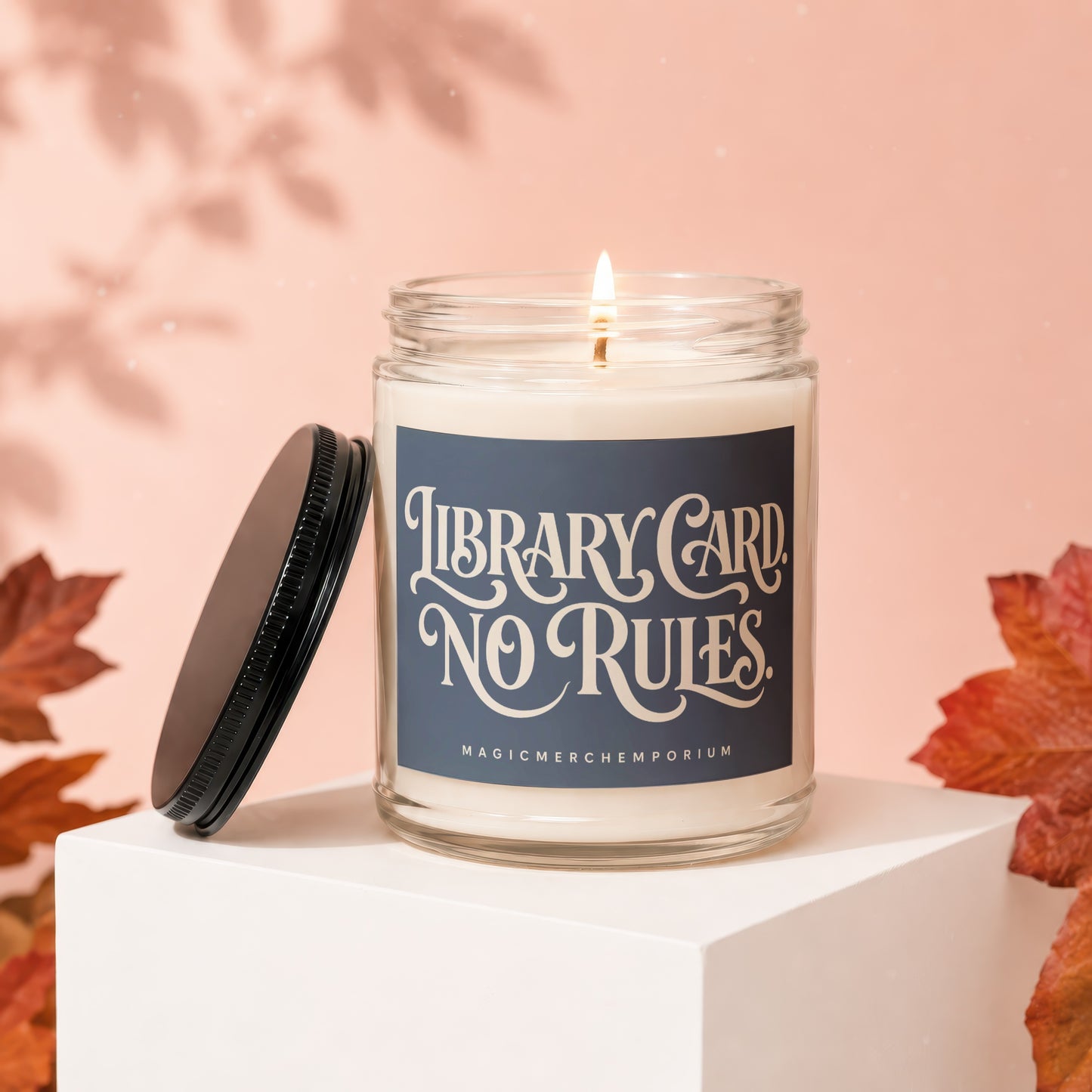 Candle with "Library Card No Rules" text and "MagicMerchEmporium" brand.