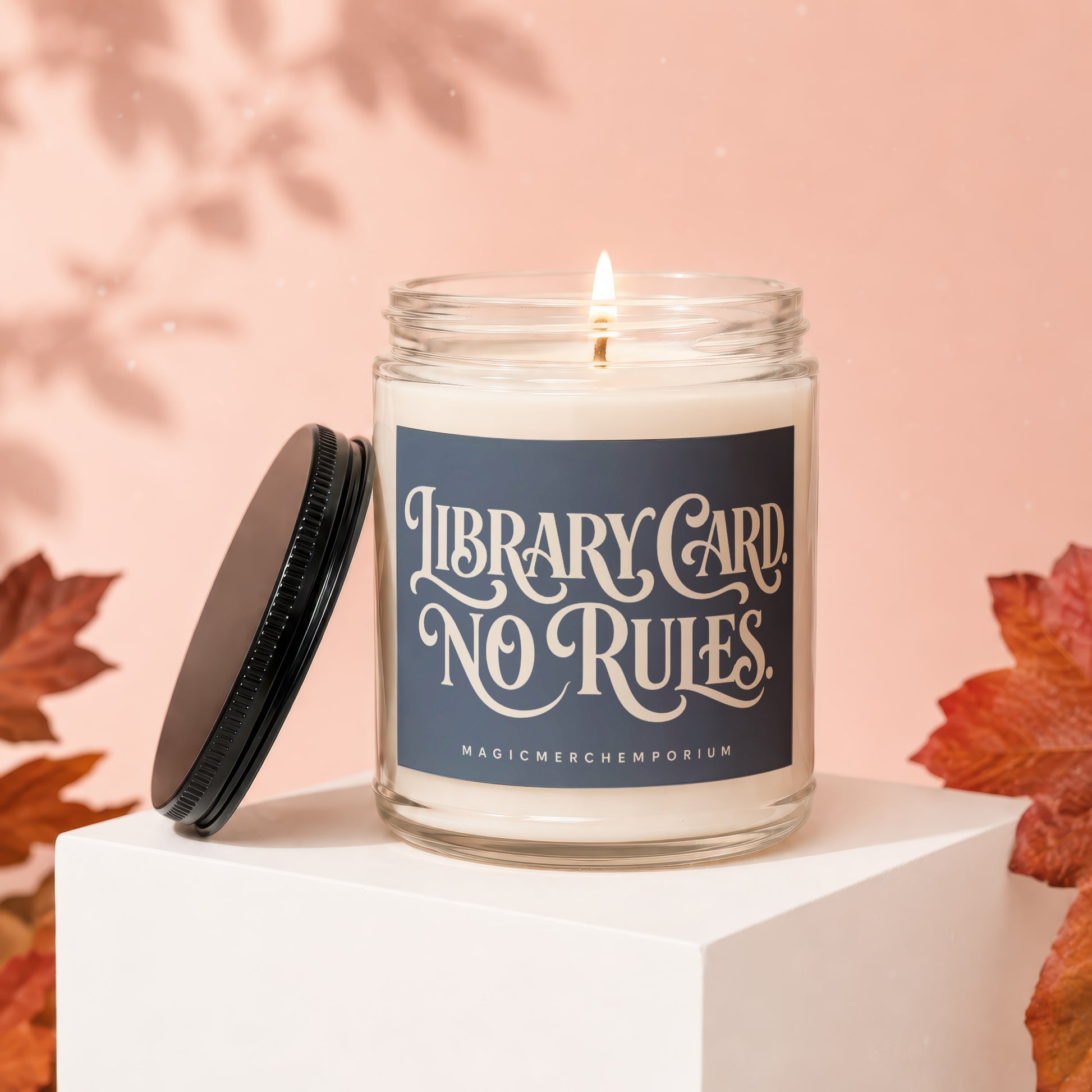 Candle with "Library Card No Rules" text and "MagicMerchEmporium" brand.