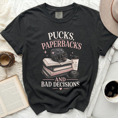 T-shirt with "Pucks, Paperbacks, and Bad Decisions" text and hockey imagery.
