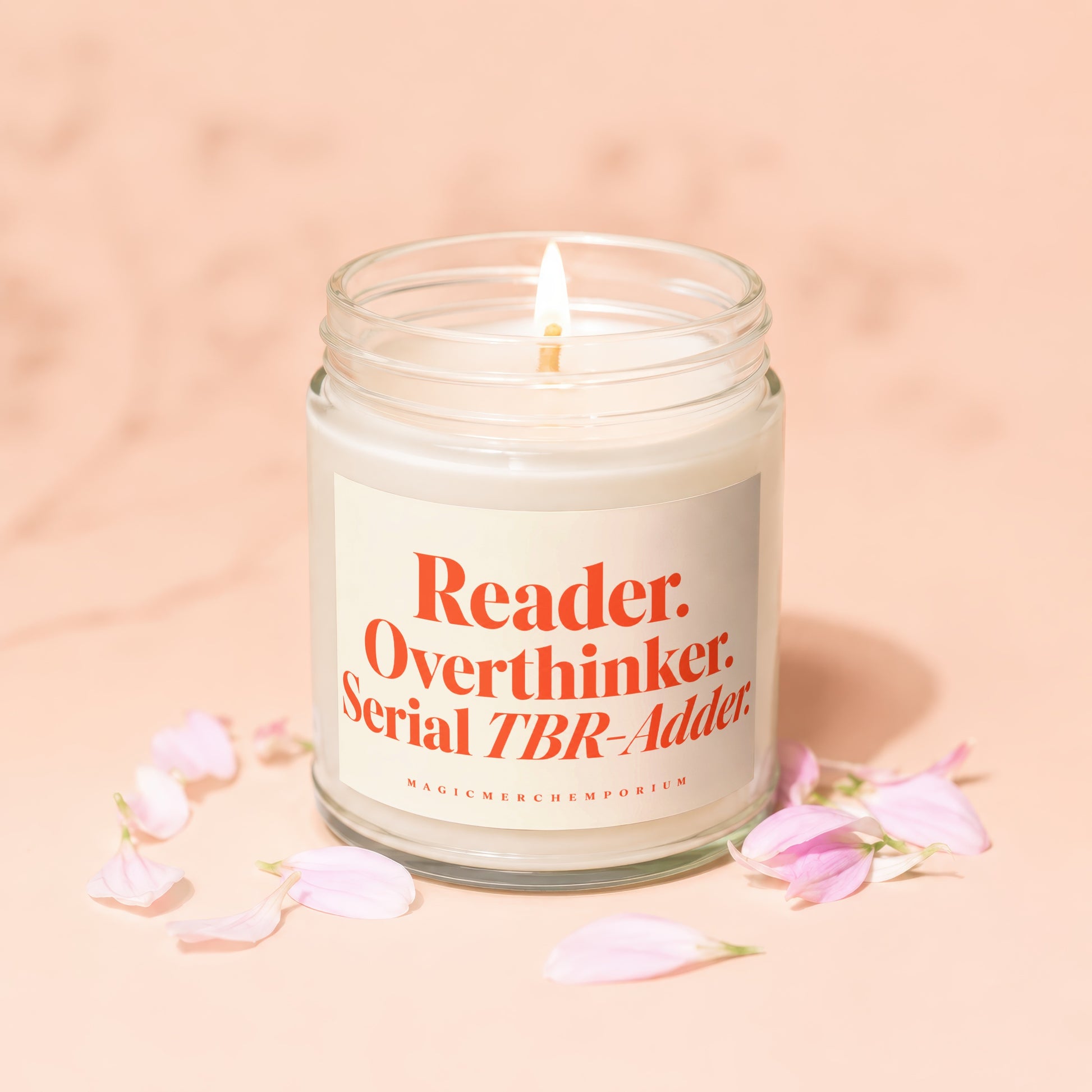 Candle with "Reader. Overthinker. Serial TBR-Adder." text, surrounded by pink flower petals.