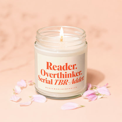 Candle with "Reader. Overthinker. Serial TBR-Adder." text, surrounded by pink flower petals.