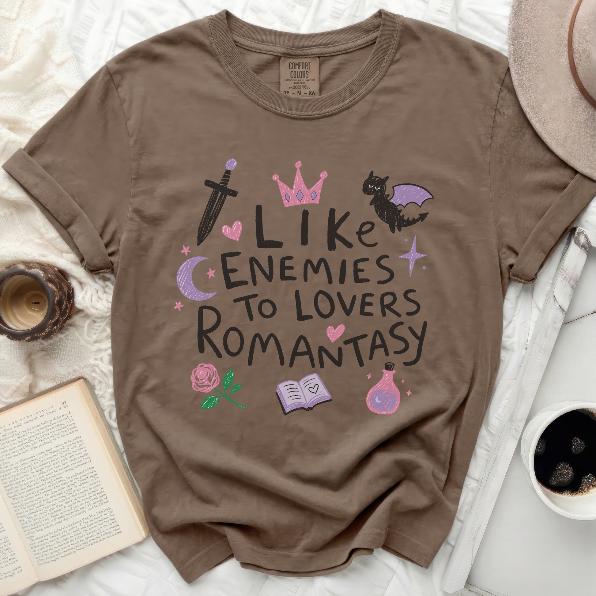 Brown t-shirt with "Like Enemies To Lovers Romantasy" graphic and fantasy icons.