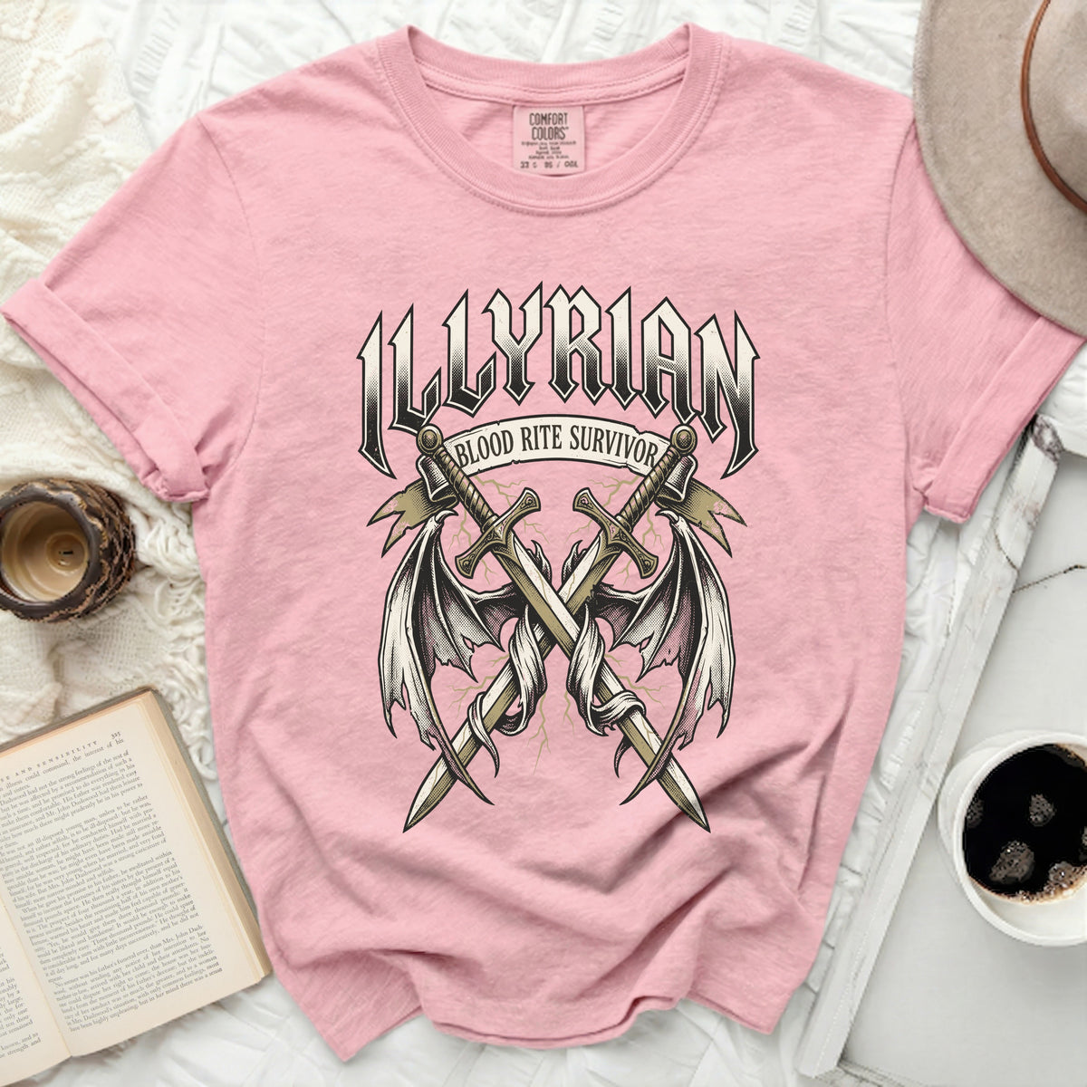 Pink t-shirt with "ILLYRIAN BLOOD RITE SURVIVOR" graphic and crossed swords.