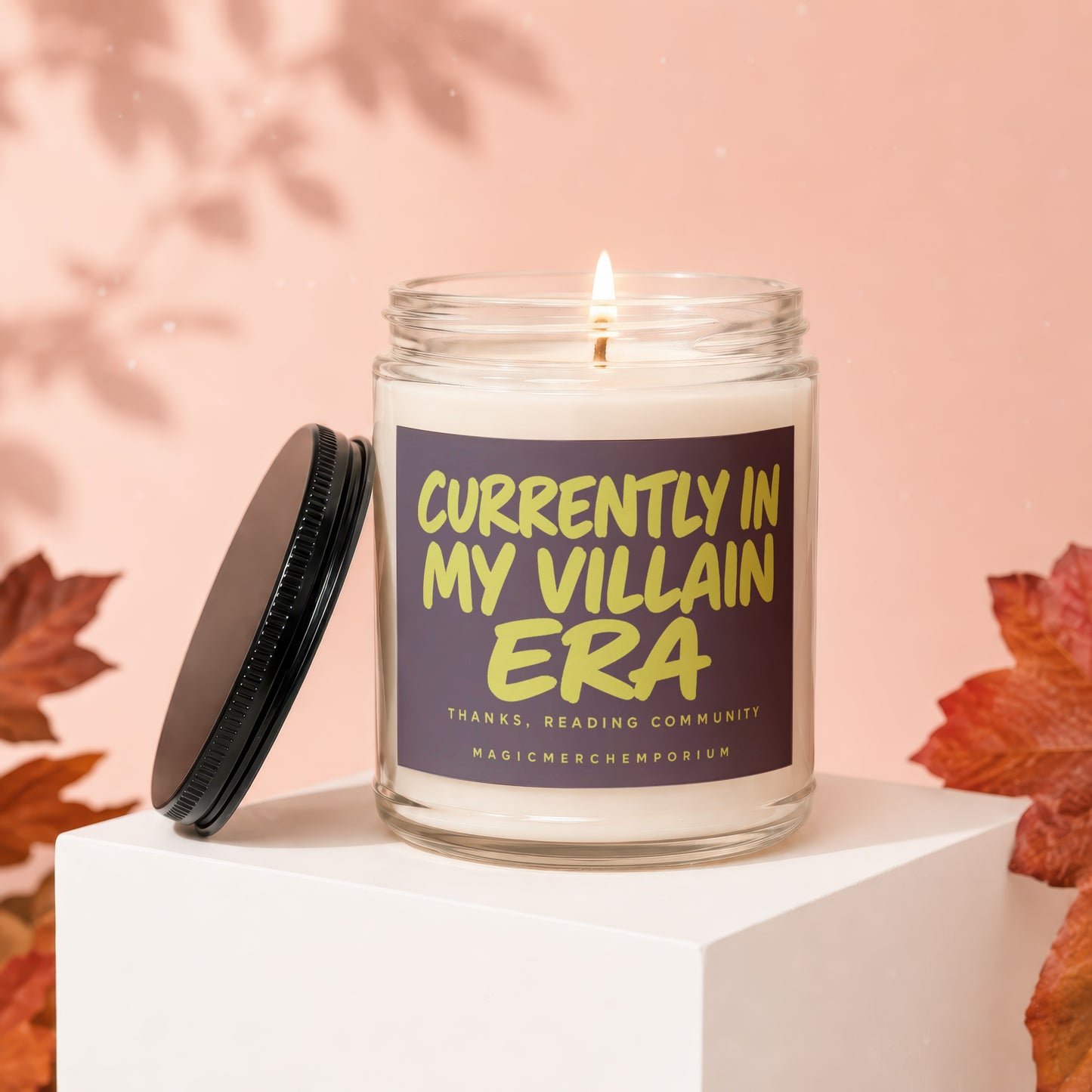 Lit candle in glass jar with label reading "Currently in my villain era".