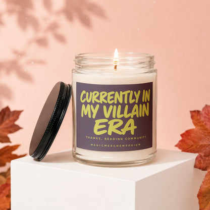 Lit candle in glass jar with label reading "Currently in my villain era".