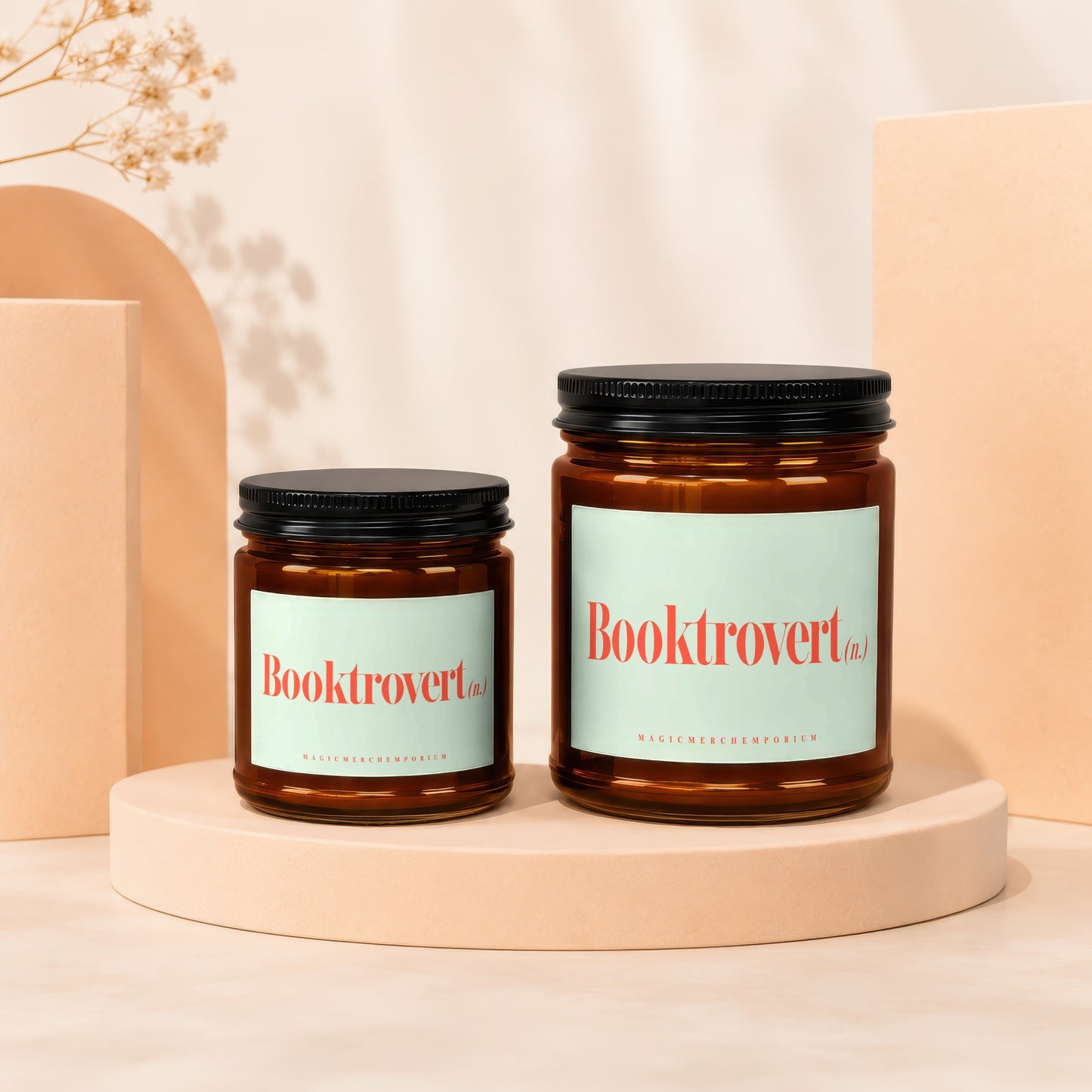 Two amber glass candles with black lids and "Booktrovert" labels.