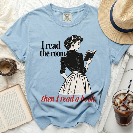 Light blue t-shirt with "I read the room. then I read a book." text and graphic.