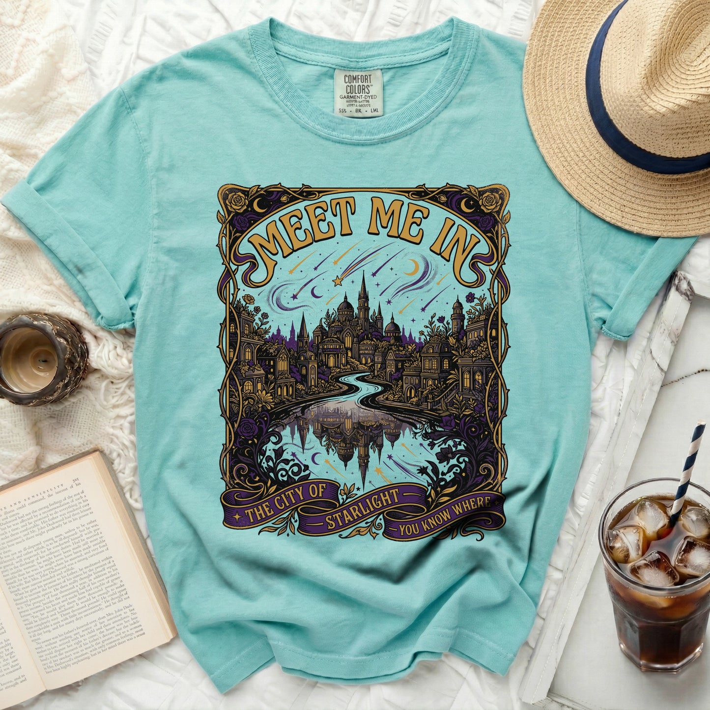 Aqua t-shirt with "Meet Me In The City of Starlight" graphic and celestial design.