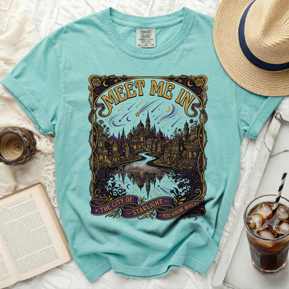 Aqua t-shirt with "Meet Me In The City of Starlight" graphic and celestial design.