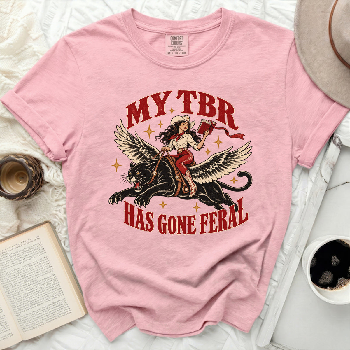 Pink Comfort Colors t-shirt with "My TBR Has Gone Feral" graphic of a woman on a winged panther.
