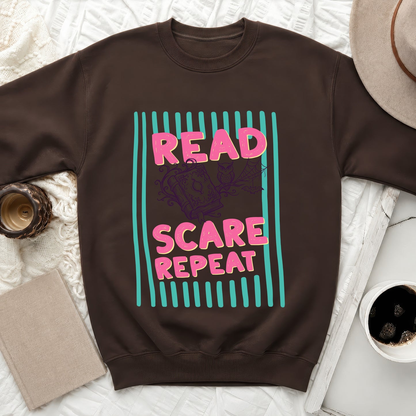 Brown sweatshirt with "Read Scare Repeat" text and Halloween graphics.