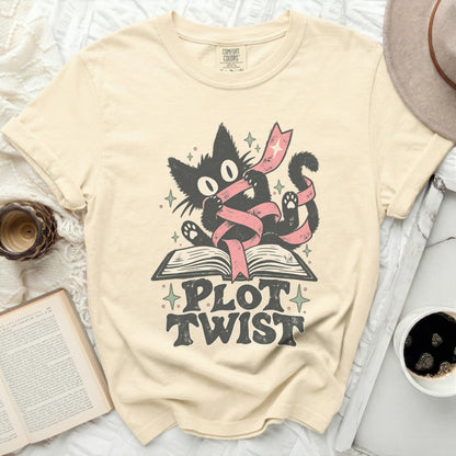 Black cat with pink ribbon on open book, text reads "PLOT TWIST."