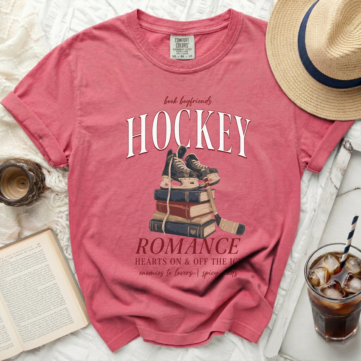 Pink t-shirt with "Hockey Romance" text and skates on books.