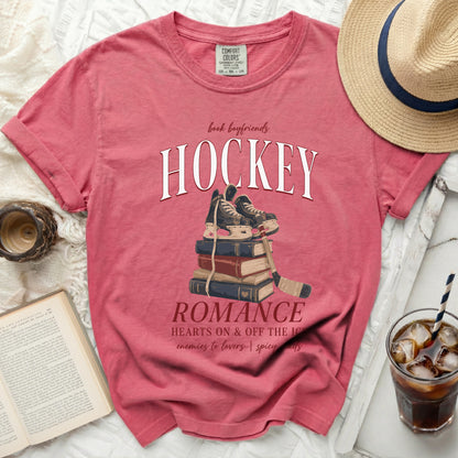 Pink t-shirt with "Hockey Romance" text and skates on books.
