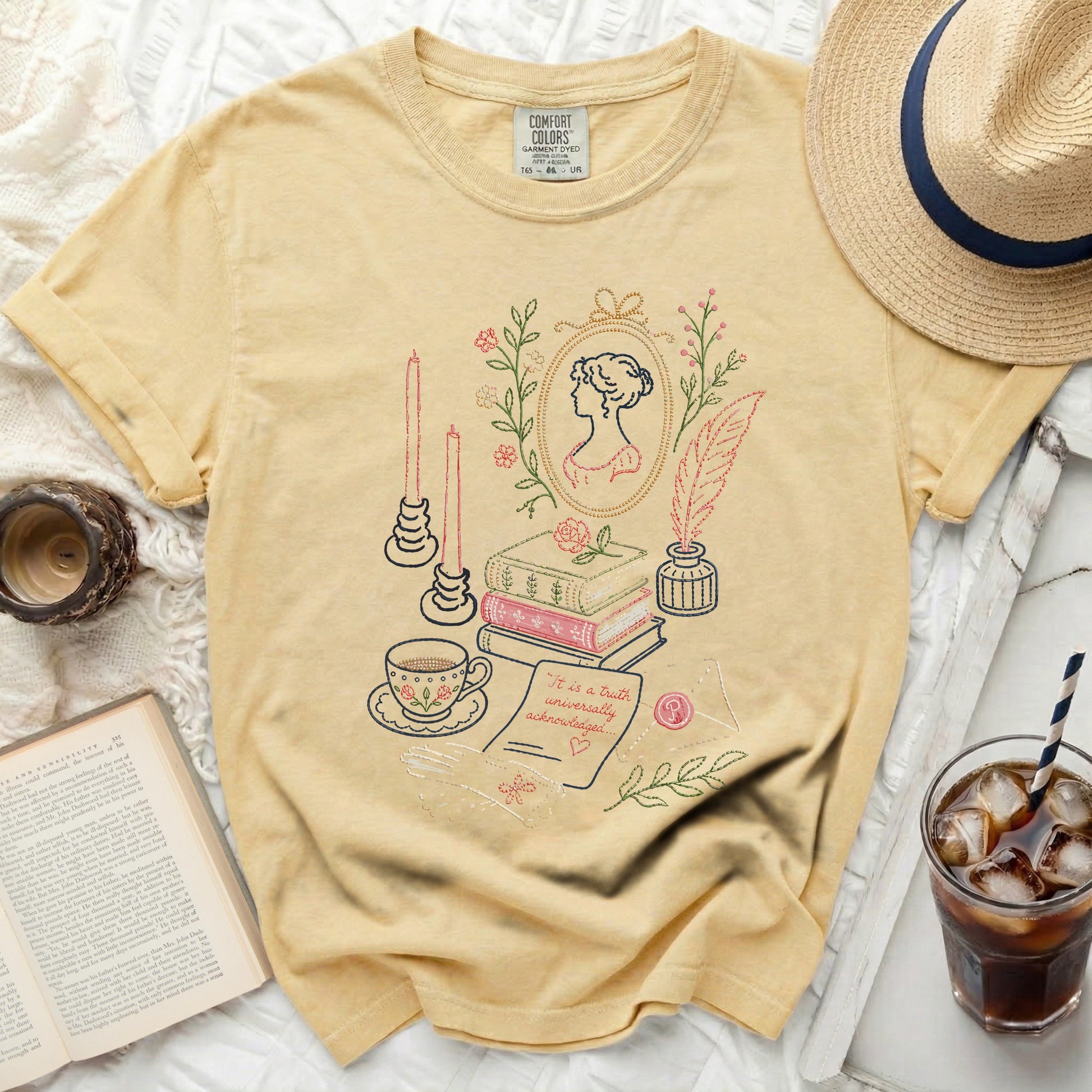 Yellow t-shirt with embroidered literary scene: portrait, books, tea, quill, candles.