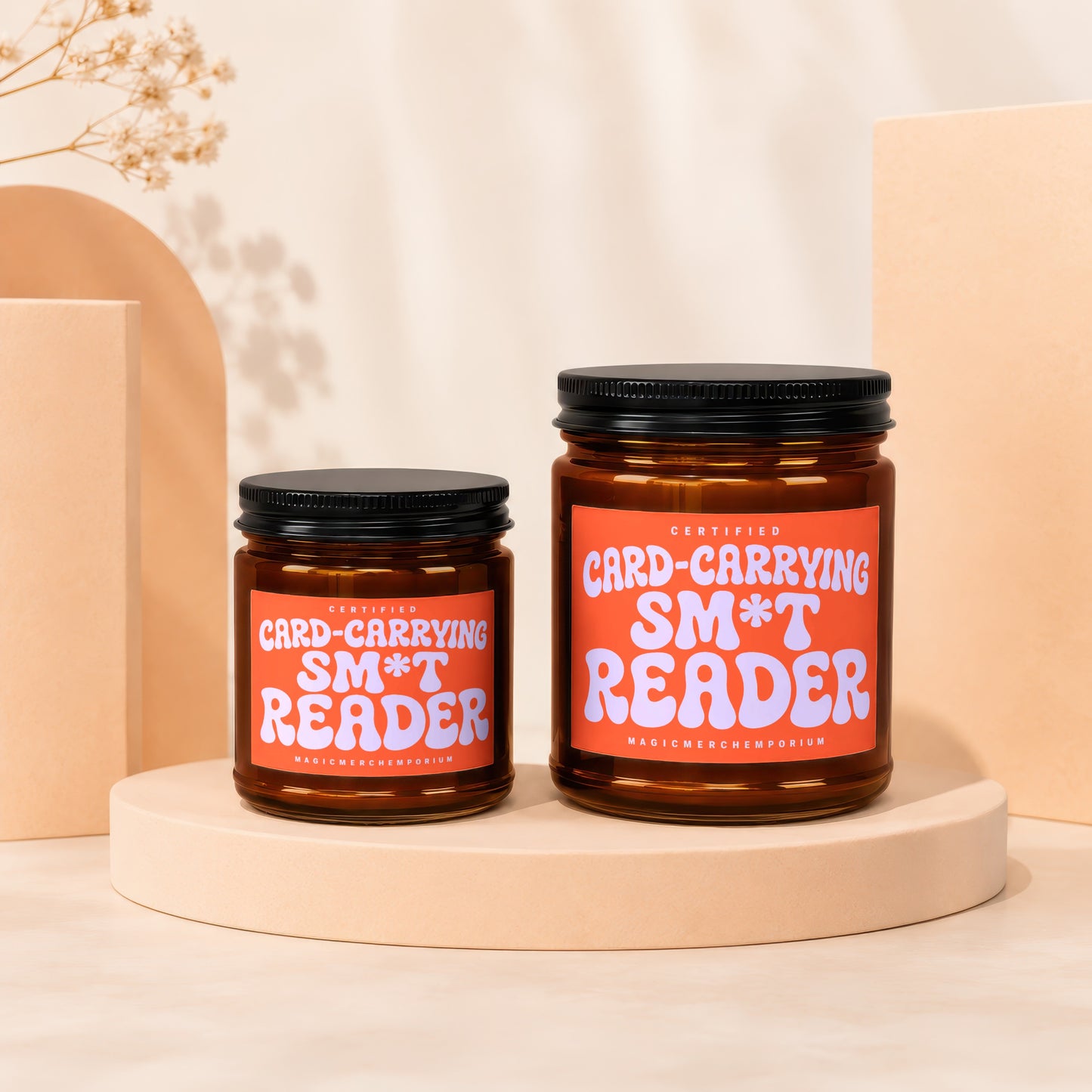 Two amber glass candles labeled "Certified Card-Carrying Sm*t Reader".