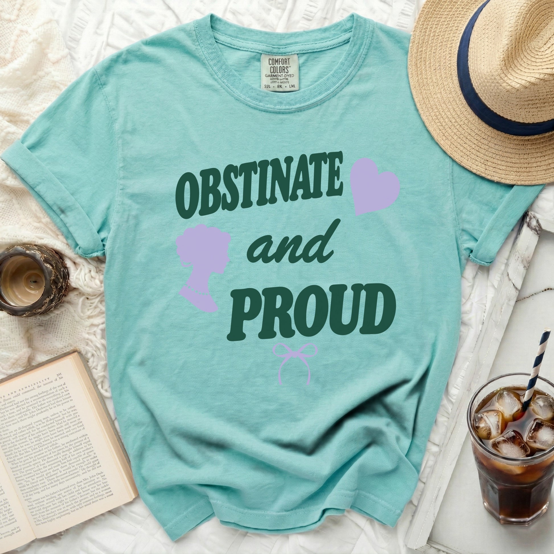 Teal t-shirt with "OBSTINATE and PROUD" text and purple graphics.