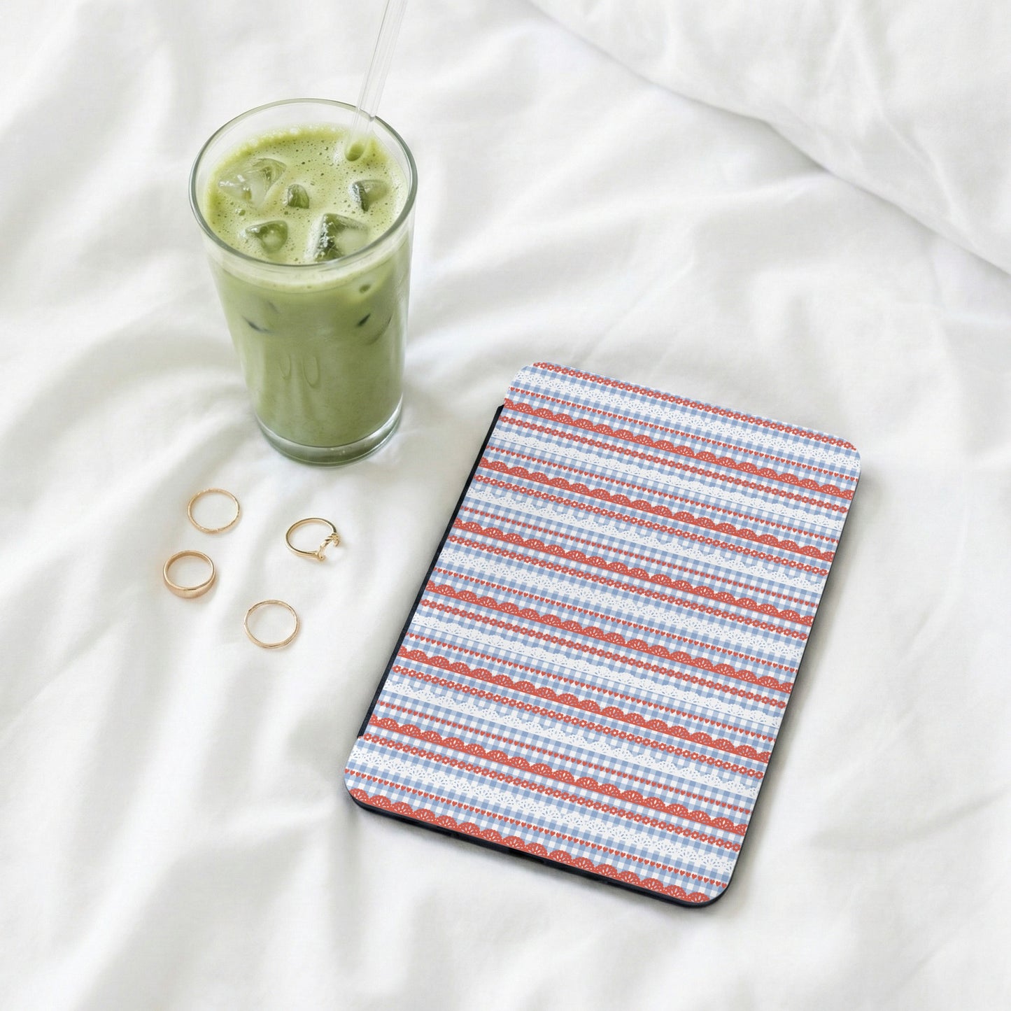 Patterned tablet case with rings and iced coffee nearby