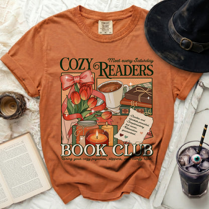 Orange t-shirt with "Cozy Readers Book Club" graphic, tulips, coffee, and candles.