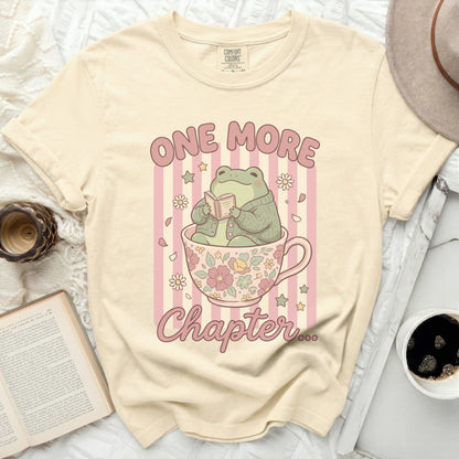 Cream t-shirt with frog reading in teacup graphic and "ONE MORE Chapter" text.