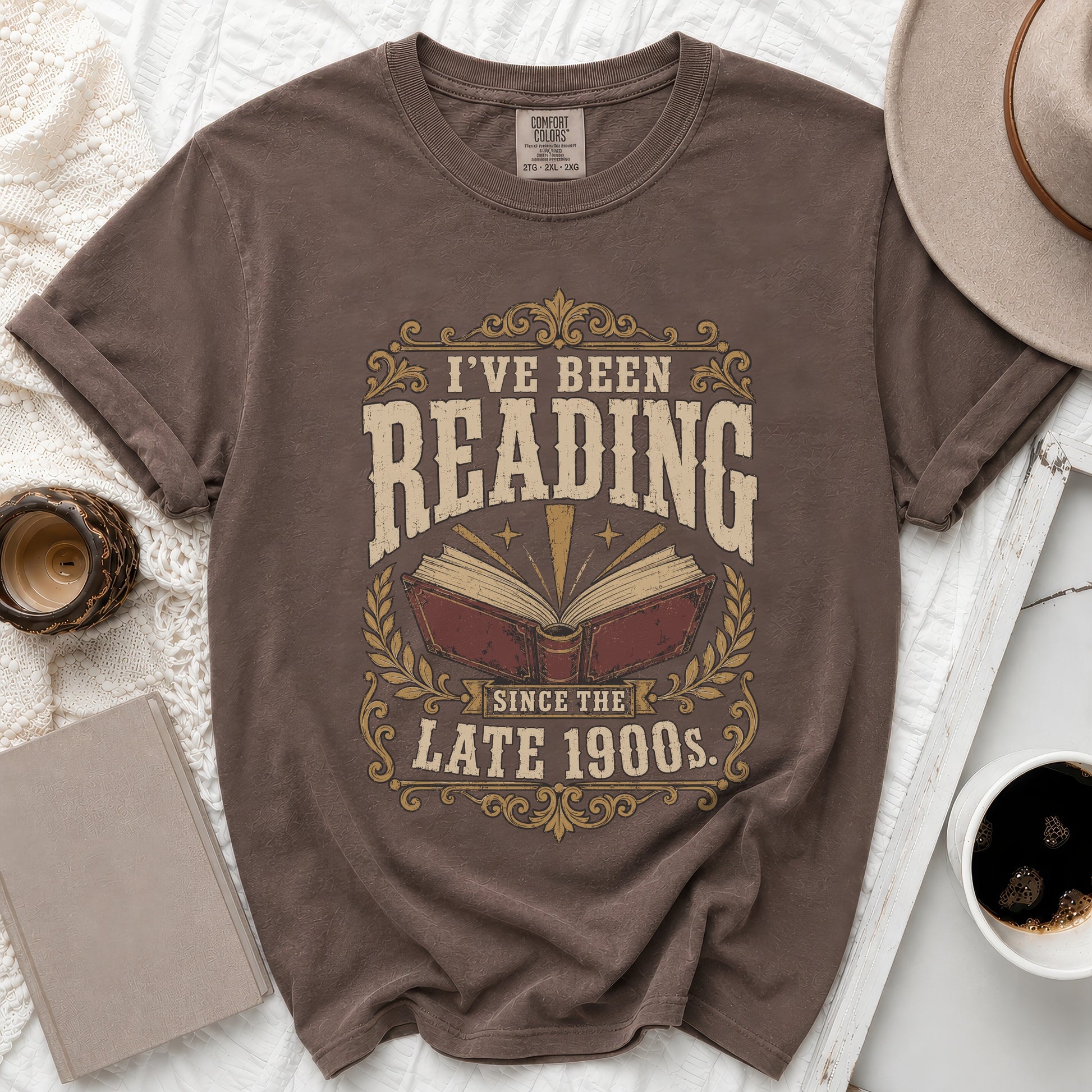 Brown t-shirt with "I've Been Reading Since the Late 1900s" text and an open book graphic.
