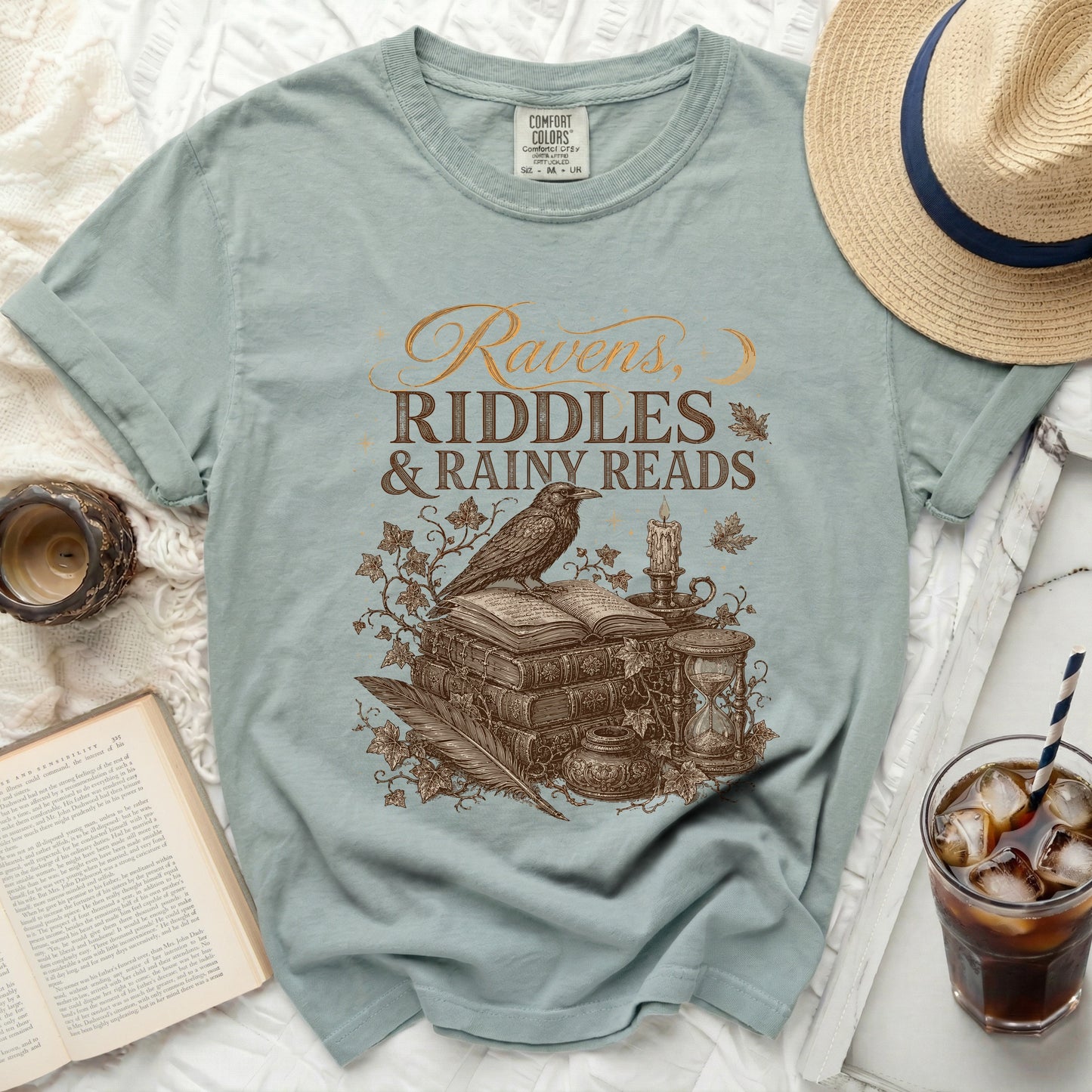 T-shirt with "Ravens, Riddles & Rainy Reads" text and illustration.
