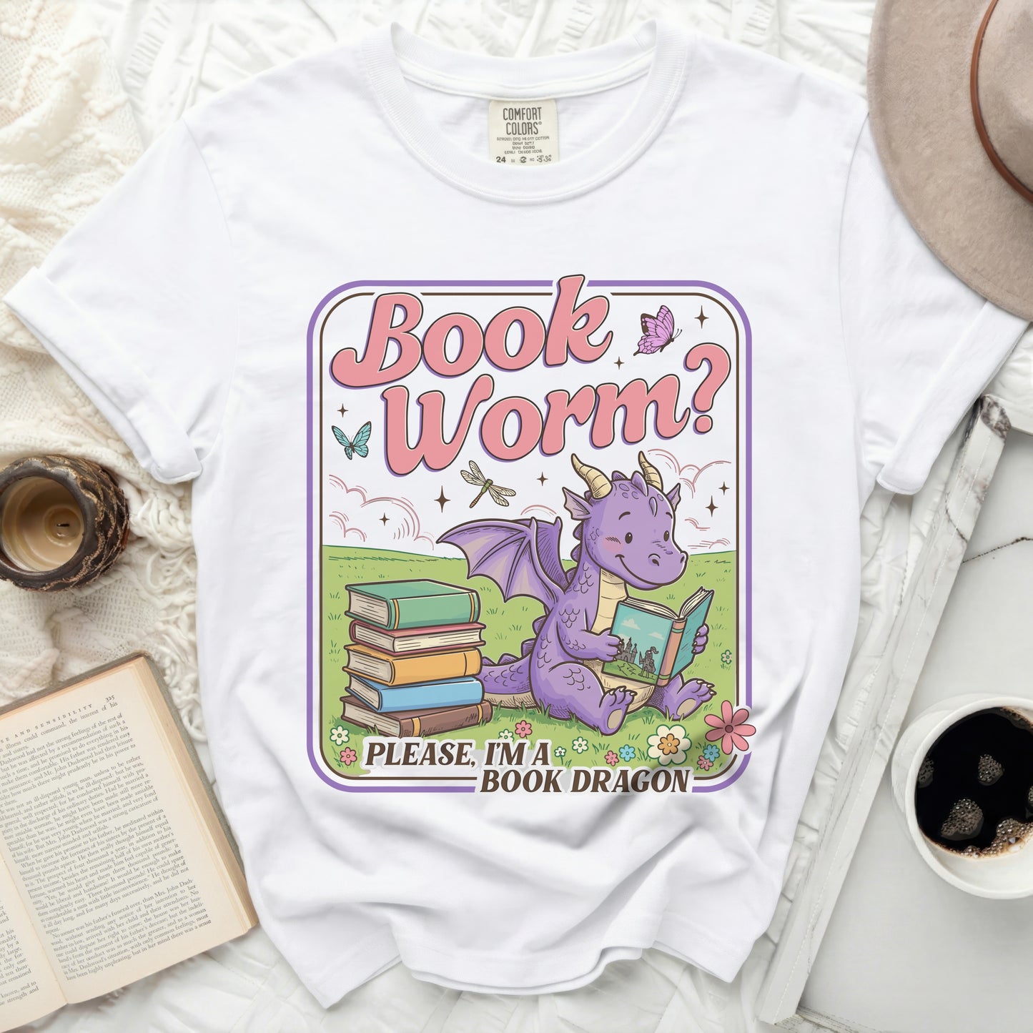 White t-shirt with a graphic of a purple dragon reading a book, text reads "Book Worm? Please, I'm a Book Dragon."