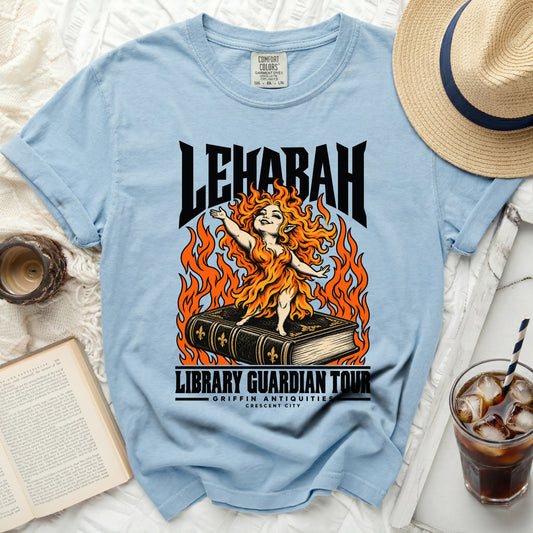 Light blue t-shirt with "LEHABAH LIBRARY GUARDIAN TOUR" graphic of a fiery woman on a book.