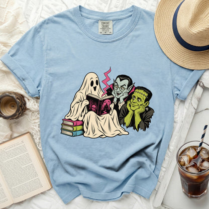 Ghost, vampire, and Frankenstein reading a book on a pile of books.