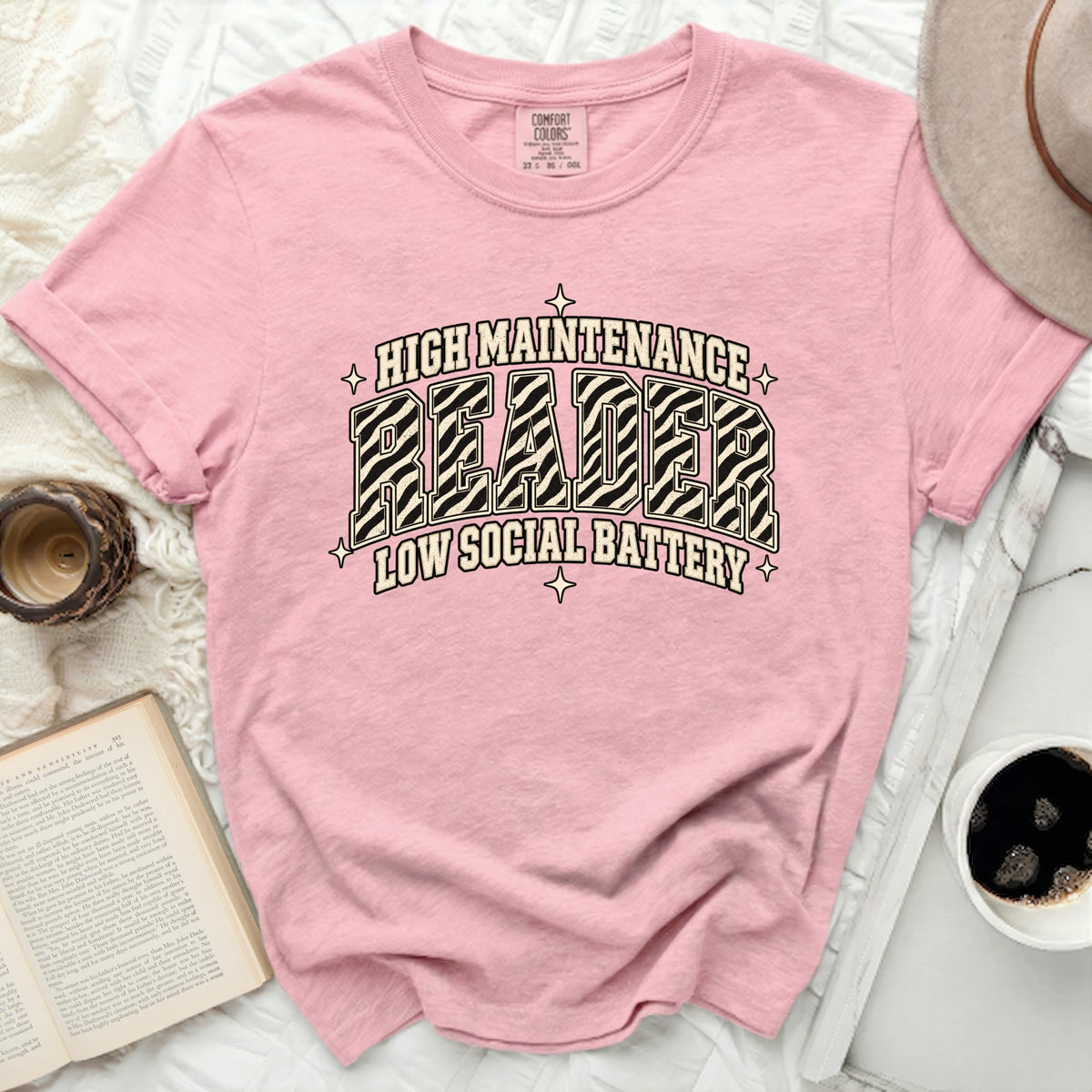 Pink t-shirt with "HIGH MAINTENANCE READER LOW SOCIAL BATTERY" text.